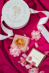 Rosee Vitae pakend koos roosiõli kapslitega roosal kangal.