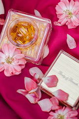 Roosiõli kapslite purk roosade lillede ja kroonlehtedega roosal taustal.